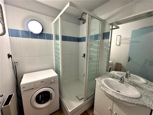 une salle de bain avec une machine à laver et un lavabo dans l'établissement Port-Vendres: T2 4 pers ascenseur, loggia ensoleillée, près des commerces - FR-1-309-188, à Port-Vendres