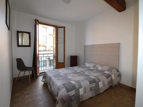 une chambre avec un lit, une chaise et une fenêtre dans l'établissement Appartement typique à Collioure, près des plages et commerces, avec cour et 3 chambres pour 6 pers. - FR-1-309-213, à Collioure