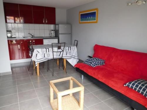un salon avec un canapé rouge et une table dans l'établissement Maison typique vendéenne, piscine privée, proche plage, 4 pers, La Faute-sur-Mer - FR-1-476-162, à La Faute-sur-Mer