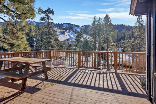 a wooden deck with a picnic table on top of it at 2235-Bear Mountain Views home in Big Bear Lake