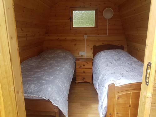 a bedroom with two beds in a log cabin at Rum Bridge Fisheries "The Cabin" in Clare
