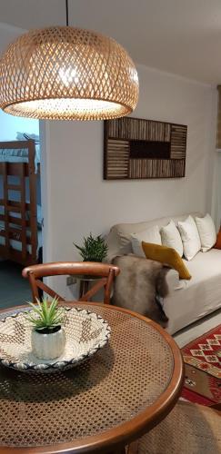 a living room with a table and a couch at Lindo y Equipado Departamento in Pucón