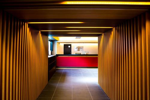 un corridoio con pareti in legno e parete rossa di Hotel Meldia Kyotoshijoomiya a Kyoto