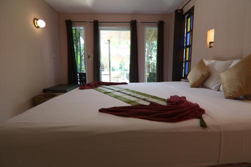 a white bed with two red towels on it at Avocado Koh Samui in Bophut 
