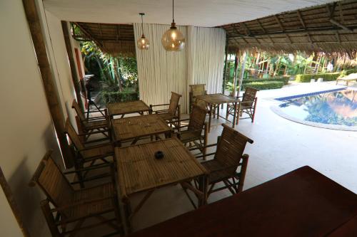 a restaurant with wooden tables and chairs and a swimming pool at Avocado Koh Samui in Bophut 