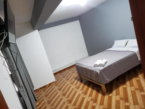 1 dormitorio con 1 cama y TV de pantalla plana en Tumalki Rooms, en Trujillo
