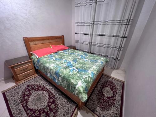 Habitación pequeña con 1 cama y 2 alfombras en Résidence lagar, en Kenitra