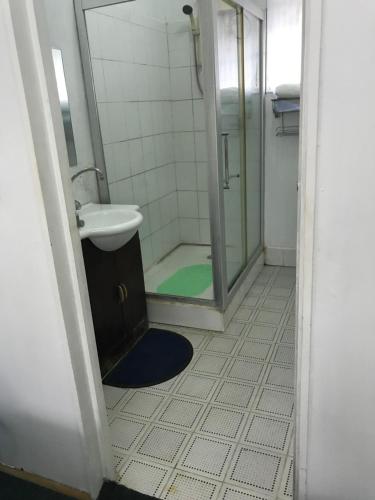 La salle de bains est pourvue d'une douche, d'un lavabo et de toilettes. dans l'établissement White House, à Suva