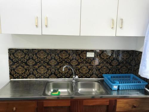 - un évier de cuisine avec un séchoir à vaisselle dans l'établissement White House, à Suva