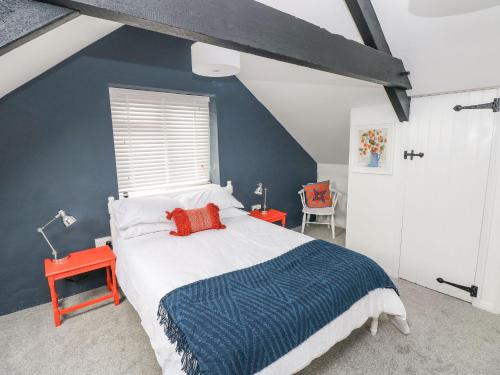 a bedroom with a bed and a blue wall at Clementine Cottage in Tenby