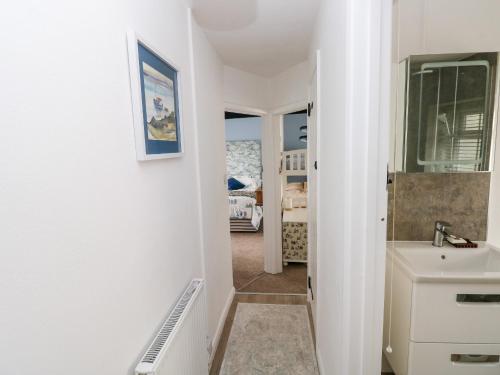 a bathroom with a sink and a mirror at Bluebell Cottage in Tenby