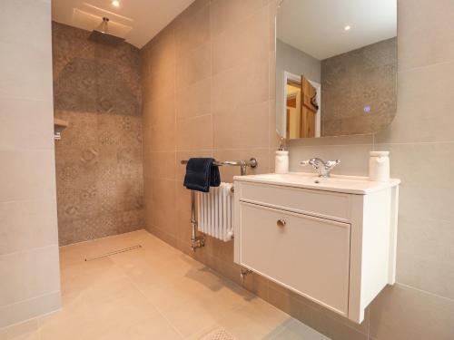 a bathroom with a sink and a mirror at Meadowside Barn in Preston