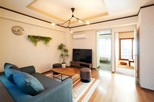 a living room with a blue couch and a table at Choetsu in Kyoto