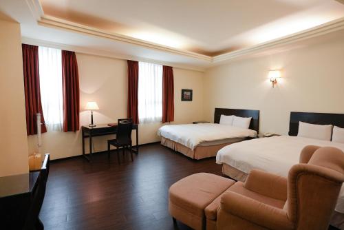 Habitación de hotel con 2 camas y sofá en Herkang Hotel en Taichung