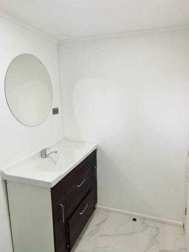 a bathroom with a sink and a mirror at La Mar Box 7 frente al Mar - Parejas in Pichilemu