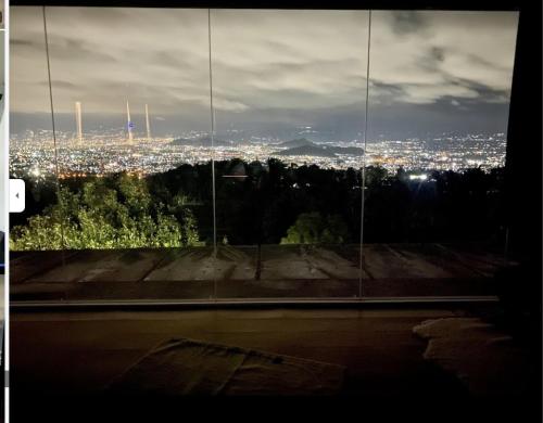 - une vue sur la ville la nuit depuis une fenêtre dans l'établissement Villa Adryan Pakuhaji Bandung, à Lembang