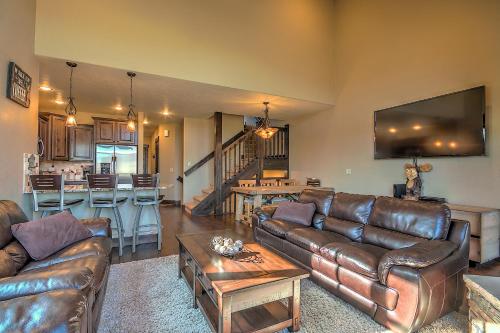 a living room with leather couches and a kitchen at 5-Star Finishings Townhome, Minutes from World Class Ski Resorts, Hot Tub home in Silverthorne