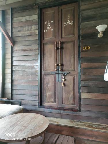 a wooden wall with a wooden door and a table at tamarind guesthouse in Phra Nakhon Si Ayutthaya