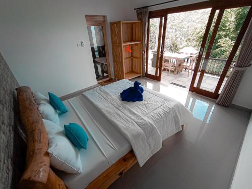 een slaapkamer met een bed met een blauwe teddybeer erop bij Kalimaja Amed Villa in Ambat