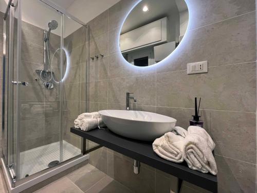 een badkamer met een wastafel en een douche met een spiegel bij Giano Host - Ponterotto in Genua