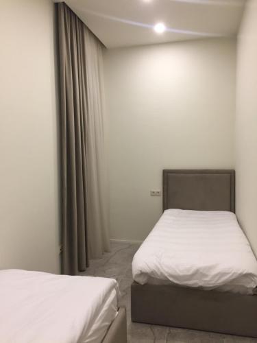 twee bedden in een kamer met witte lakens bij Apartment in Yerevan Moskovyan in Jerevan