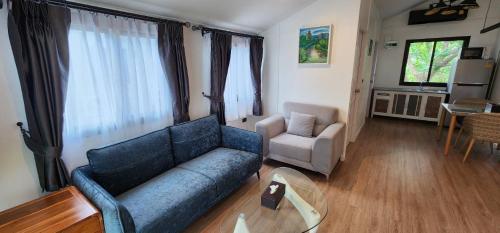 a living room with a blue couch and a chair at The Nidhra Boutique Resort in Baan Tai