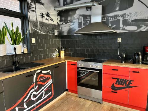 uma cozinha com armários vermelhos e uma moto pintada na parede em Vakantiehuis centrum Schagen nabij zee / strand em Schagen