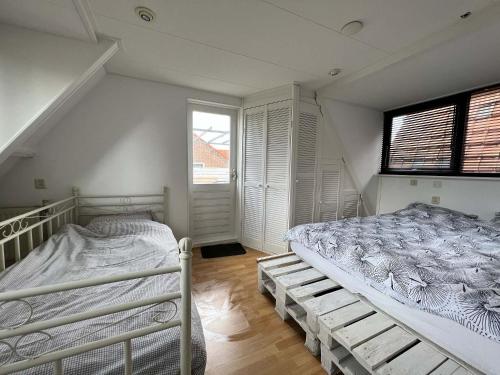 um quarto com 2 beliches e uma janela em Vakantiehuis centrum Schagen nabij zee / strand em Schagen