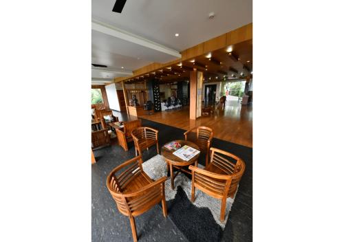 a restaurant with wooden chairs and a table at Chandys Windy Woods Munnar in Munnar