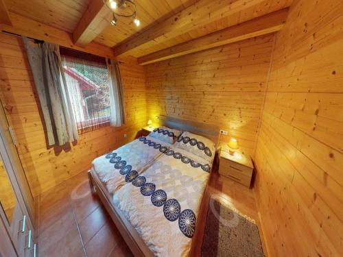 a bedroom with a bed in a wooden cabin at Chalet Bodensdorf near Gerlitzen Ski Area in Tratten