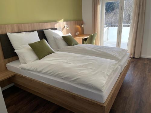 a large bed with white sheets and green pillows at WineArtB&B 