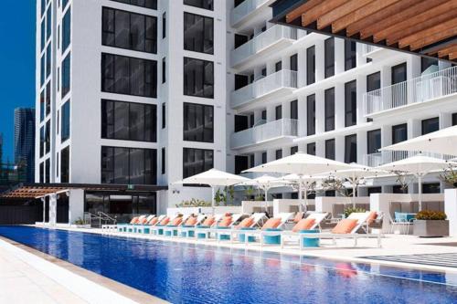 a hotel with a swimming pool with chairs and umbrellas at Central Brisbane2BedsPark+Super big balcony! in Brisbane