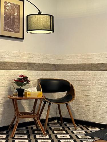 a black chair sitting next to a table with a lamp at G Beach Front Villa in Batu Ferringhi