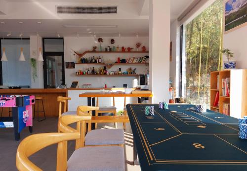 DeqingにあるMoganshan Naicang Boutique Hotelのテーブルと椅子、カウンターが備わる客室です。