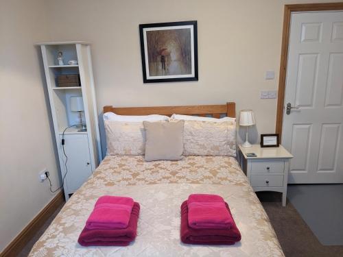 - une chambre avec un lit doté de 2 oreillers roses dans l'établissement Mariners Rest, à Morpeth
