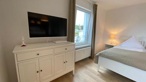 a bedroom with a bed and a television on a dresser at Villa Rosalie Sassnitz in Sassnitz