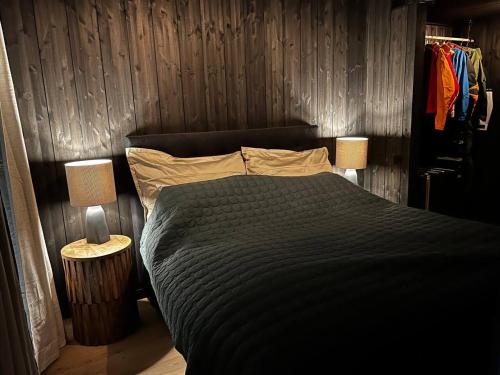 a bedroom with a black bed and two lamps at Kikut Alpin Lodge - Ski In/Ski Out - Ny 2022 in Geilo