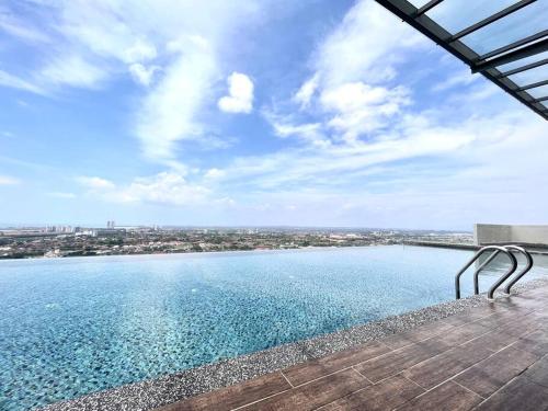 a bench sitting on a deck next to a body of water at Ins Suite @ The Quartz Residence-Infinity Pool in Melaka