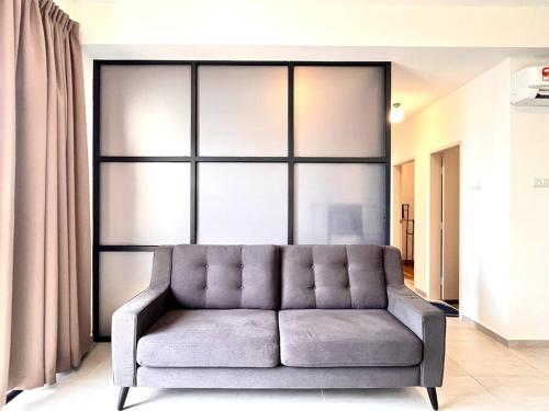 a couch in a room with a large window at Ins Suite @ The Quartz Residence-Infinity Pool in Melaka