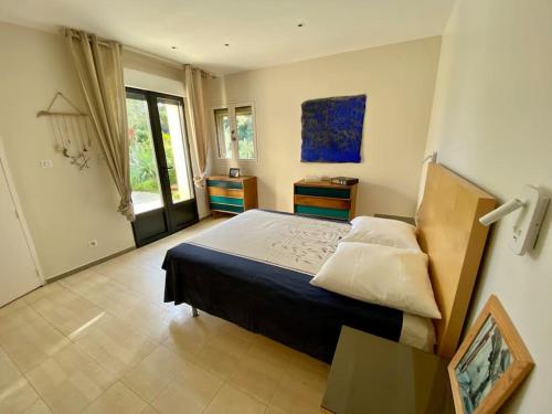 Un dormitorio con una cama grande y una ventana en villa d'exception avec piscine , au bord de la mer, en Hyères