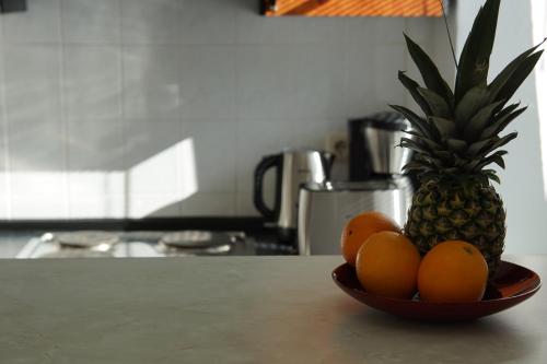 a bowl of oranges and a pineapple on a kitchen counter at Villa Rosalie Sassnitz in Sassnitz