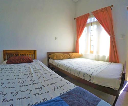 dwa łóżka w pokoju z oknem w obiekcie 20 House Villa w mieście Arugam Bay