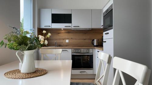 a kitchen with a table with a vase of flowers on it at Villa Rosalie Sassnitz in Sassnitz