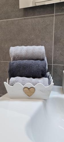 un mucchio di asciugamani su una mensola in bagno di IO E TE bed and breakfast Appartamento a Cuneo