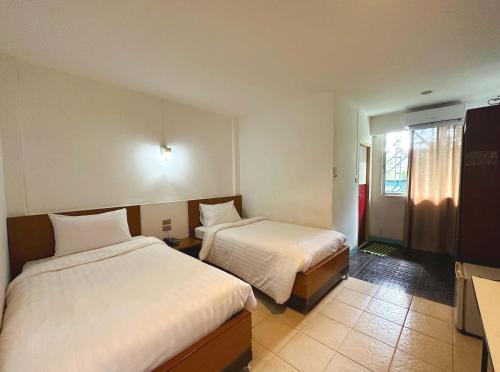 Postel nebo postele na pokoji v ubytování Plernpetch Hotel