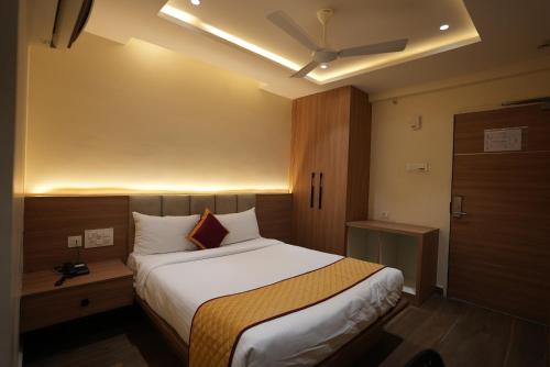 a hotel room with a large bed and a door at HOTEL SUNRISE HOSPITALITY in Vijayawāda