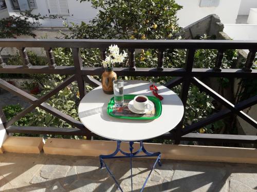 a table on a balcony with a cup of coffee at DELFINI I in Fira