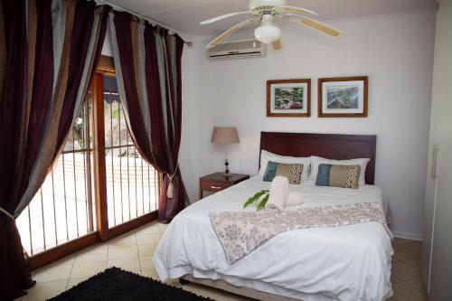 a bedroom with a bed and a ceiling fan at Mamma Mia House in Sandton