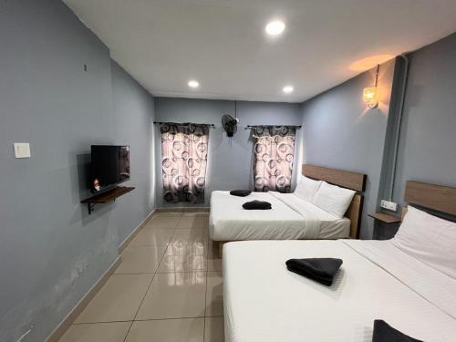 pokój hotelowy z dwoma łóżkami i telewizorem w obiekcie Hotel Yasmin w mieście Brinchang