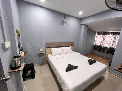 ein Schlafzimmer mit einem Bett mit zwei Kissen darauf in der Unterkunft Hotel Yasmin in Brinchang